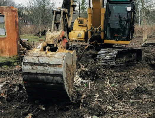 Excavator working on a property for emergency environmental services.