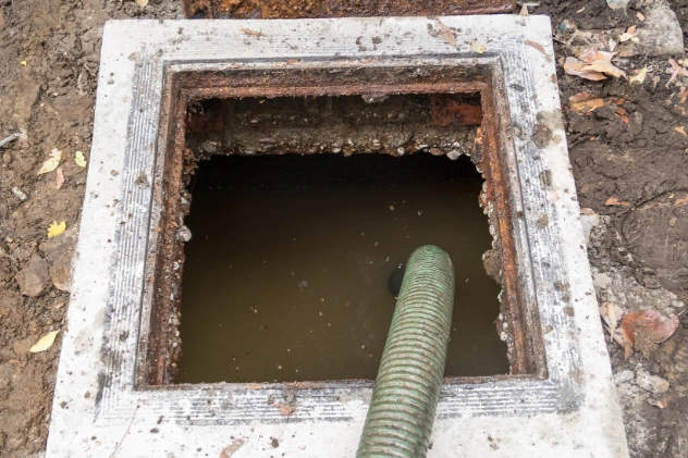 Sewage tank with water and a hose inserted for pumping out waste.