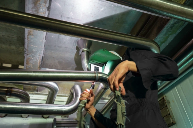 Plumber working on large pipes for commercial plumbing installation.