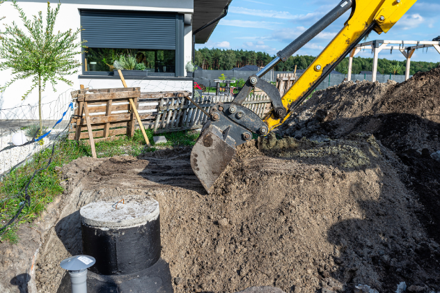 Excavator digging around a septic system for repair work.