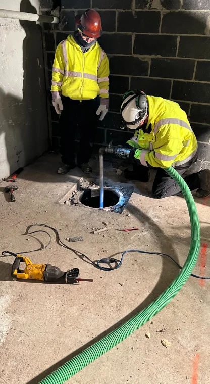 Plumbers using equipment to clean sewer lines