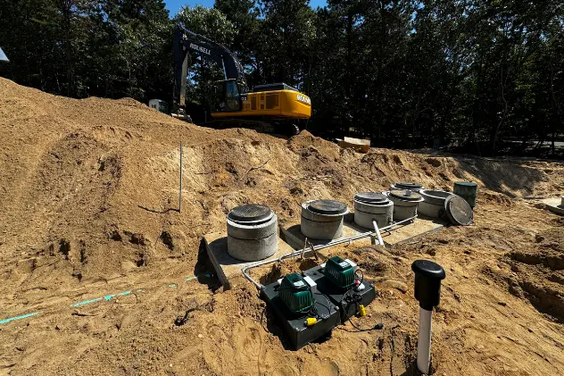 Sewer treatment facility under construction with excavation equipment