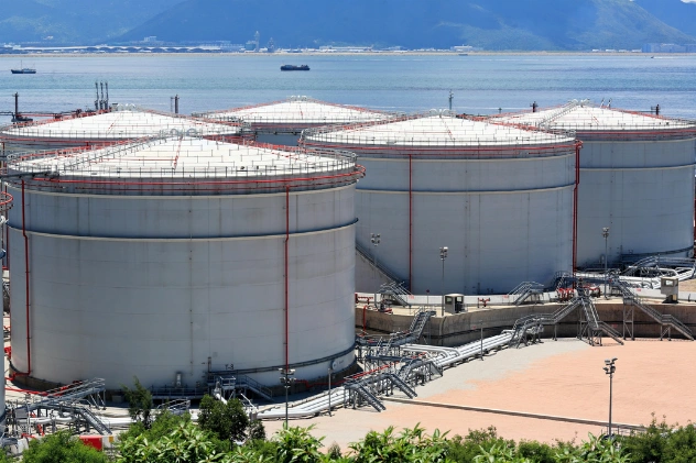 Large industrial oil storage tanks on the shoreline