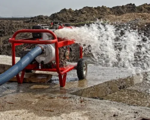 Industrial pump releasing water from a hose at construction site